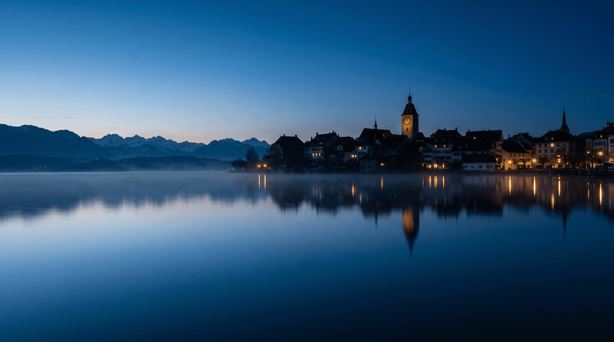 بحيرة تسوغ مع أبراج المدينة القديمة منعكسةً في الماء في بعد ظهيرة صافية